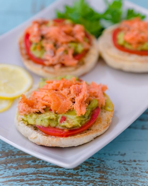 Avocado toast with smoked salmon on crisp toasted English muffins topped with tomato, Sabra's new Veggie Fusions guacamole + veggies is the perfect healthy lunch for busy days.