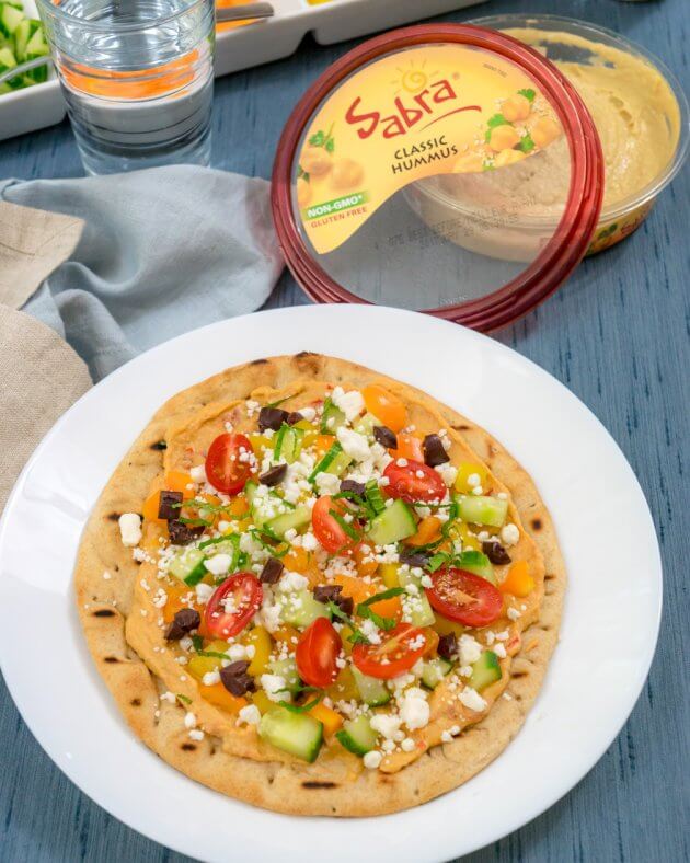 Quick and easy grilled pita pizza topped with hummus and fresh ingredients are healthy and filling. Make for a quick lunch, dinner, or healthy appetizer.